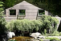 Maison en bois et jardin avec étang