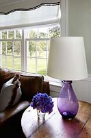 Fleurs de pensée violette et lampe sur table d'appoint en bois
