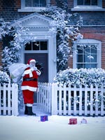Père Noël devant une maison