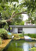 Maison moderniste et jardin avec étang