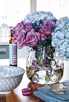 Vase de roses et de fleurs d'hortensia sur le comptoir de la cuisine