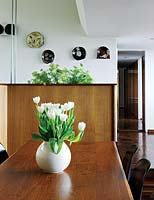 Vase de tulipes blanches sur table à manger en bois