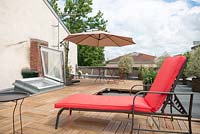 Chaise longue rouge sur le toit-terrasse