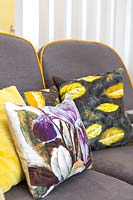 Coussins colorés en tissus vintage sur canapé Ercol