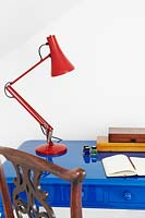 Lampe rouge sur le bureau bleu