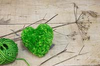 Un pompon coeur vert en laine