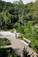 Jardin tropical avec zone pavée et statues