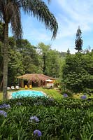 Jardin tropical avec pavillon d'été et piscine