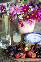 Fruits frais et fleurs sur table de jardin