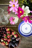Fruits frais et fleurs sur table de jardin
