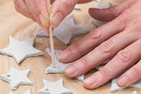 Faire des étoiles d'argile - Utilisez une brochette en bois pour créer de petits trous sur la pointe de chaque étoile