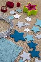 Faire un sapin de Noël en feutre - Les matériaux requis sont du feutre coloré, du fil fin, un crayon, un pompon et des couteaux en forme d'étoile
