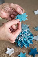 Faire un sapin de Noël en feutre - Ajoutez les étoiles en feutre au fil mince dans l'ordre de taille du plus grand au plus petit