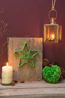 Faire une décoration d'étoile de Noël - Un socle décoratif avec une étoile de laine verte enroulée autour d'ongles de cuivre