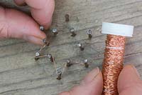 Faire des décorations d'étoiles en fil de cuivre - Tisser le fil de cuivre autour des ongles pour former une étoile