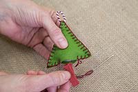 Faire des décorations de Noël en feutre cousu - Coudre un morceau de ficelle colorée à la base de la forme