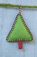 Faire des décorations de Noël en feutre cousu - arbre de Noël miniature en feutre et chaîne décorative, accroché contre un panneau en bois