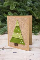 Faire des cartes d'arbre de Noël en feutre - Une carte de Noël faite à la main avec un arbre de Noël en couches sur un fond blanc