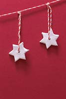 Étoiles en argile miniatures suspendues à une chaîne rayée rouge et blanche