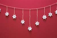 Étoiles en argile miniatures suspendues à une chaîne rayée rouge et blanche