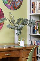 Vase de feuillage d'eucalyptus sur un bureau en bois