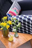 Vases de Narcisse et de fleurs Freesia sur table d'appoint rétro