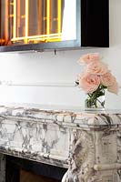 Vase de roses sur une cheminée en marbre