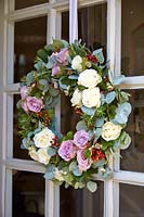 Porte d'entrée avec couronne de roses et feuillage d'eucalyptus