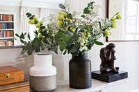 Feuillage de roses et d'eucalyptus dans un vase noir