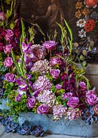 Affichage floral avec des roses roses, des hortensias, des glaïeuls et des fleurs d'Echeveria en auge
