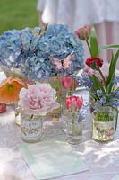 Affichage floral de pivoine, hortensia et fleurs de tulipe sur table de jardin