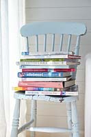 Pile de livres sur une chaise bleue