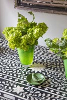 Récipients en verre vert avec des fleurs de viorne