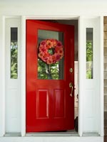 Porte d'entrée rouge avec couronne florale
