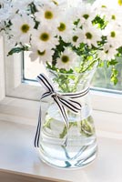 Vase de fleurs sur le rebord de la fenêtre