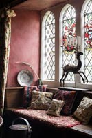 Siège de fenêtre avec coussins représentant des souches anciennes et des vitraux - Cothay Manor
