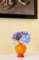Fleurs bleues dans un vase orange