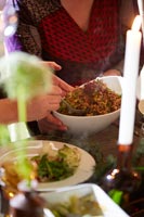 Servir un plat de plats chauds à la table à manger décorée