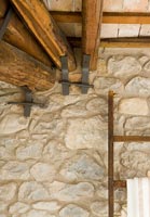 Détail de mur en pierre rustique et poutres en bois