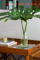 Vase de feuillage sur table à rouleaux en bois