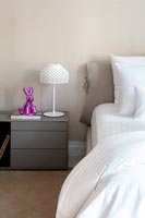 Table de chevet grise moderne avec ornement lapin rose et lampe blanche