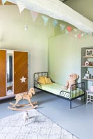 Chambre d'enfants avec méridienne en fer et jouets