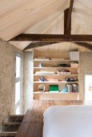 Étagères dans une chambre en bois moderne avec poutres apparentes et plafonds en bois