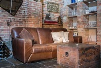 Canapé classique en cuir avec mur de briques et rangement