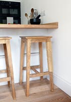 Tabourets de bar en bois avec un griffoir pour chat sur une jambe de tabouret