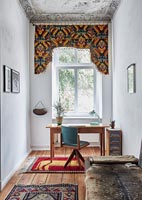 Étude éclectique avec tissu décoratif coloré sur fenêtre