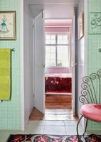Salle de bain classique avec mur carrelé vert et vue à travers la porte de la chambre