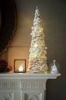 Sapin de Noël blanc et décorations sur la cheminée