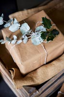 Cadeaux emballés dans du papier brun avec un feuillage décoratif