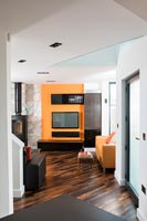 Télévision orange et poêle à bois dans le salon moderne